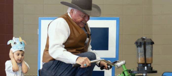 Commissioner Miller rides stationary bike connected to a smoothie machine making healthy snacks for kids